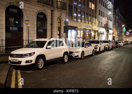 Rangée de voitures garées allemand blanc principalement dans le centre-ville de Leeds de nuit Banque D'Images