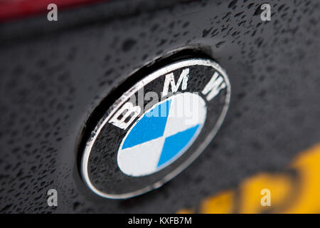 Badge BMW close up detail of a Black F83 2016 BMW M4 Cabriolet voiture avec des gouttelettes d'eau formant de la pluie Banque D'Images