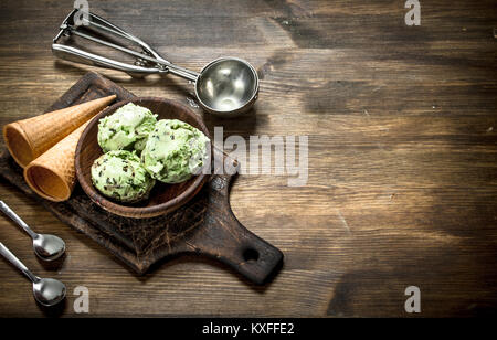 Crème glacée à la pistache fraîche dans un bol avec des tasses. Sur une table en bois. Banque D'Images
