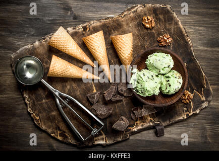 Crème glacée à la pistache fraîche dans un bol avec des tasses. Sur une table en bois. Banque D'Images