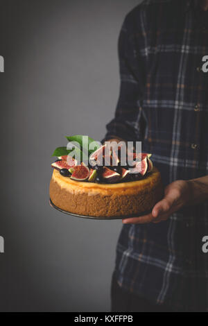 La tenue en main. Gâteau au fromage Gâteau au fromage fait maison avec des fruits dans les mains. Selective focus Banque D'Images