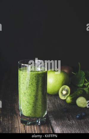 Jus détox smoothie vert en verre sur la table en bois. Image aux couleurs, fond sombre Banque D'Images