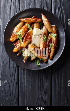 Oignons caramélisés croustillante échalote avec du fromage bleu et le persil libre sur une plaque sur une table. Haut Vertical Vue de dessus Banque D'Images