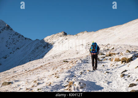 Marcher vers Swirral sur le bord de Montagnes Helvellyn en hiver, Lake District, Cumbria, Angleterre. Banque D'Images