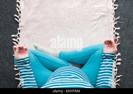 Vue supérieure de l'exercice pratique le yoga de la femme enceinte à la maison. Le yoga et la grossesse à l'intérieur concept de remise en forme. Images à faible contraste de l'ungraded avec natur Banque D'Images