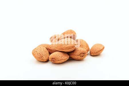 Un tas d'amandes en coque sur fond blanc Banque D'Images