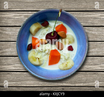 Petit déjeuner d'un lait de soja avec cherry, l'écrou, almondand avec mélange de petits fruits de banane et de papaye dans un petit bol sur la table en bois, vue du dessus de l'arrière-plan Banque D'Images
