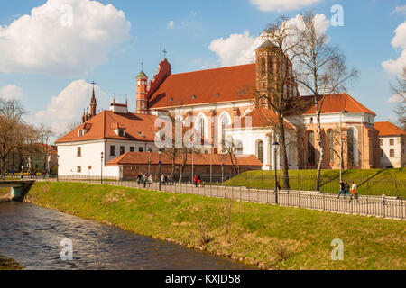 Vilnius, Lituanie - Avril 2, 2017 : Les gens en passant devant l'église de Saint François et de Saint Bernard, près de la rivière Vilnia sur une journée de printemps ensoleillée. Banque D'Images