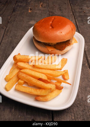 Burger de poisson avec frites sur une assiette blanche Banque D'Images