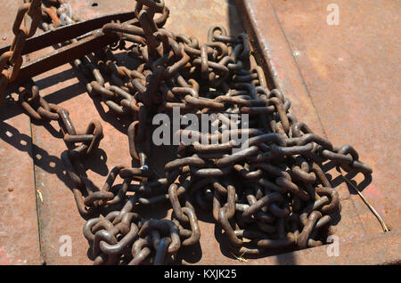 Old rusty chaînes sur la surface rouillée de fer avec une ombre de bars en tant que symbole d'emprisonnement Banque D'Images