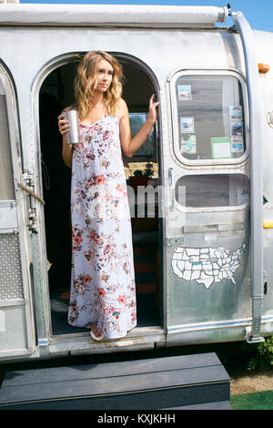 Jeune femme portant le regard de robe porte Airstream Banque D'Images