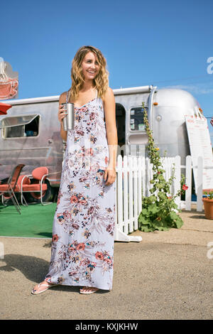 Jeune femme en robe maxi par airstream coffee shop Banque D'Images