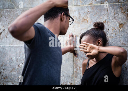 Jeune homme violent menace sa petite amie avec son poing outdo Banque D'Images