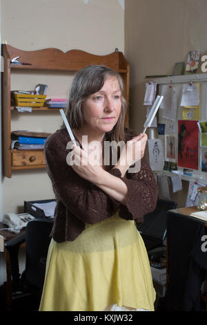 Femme qui souffre du syndrome d'hypersensibilité électromagnétique de l'intolérance qui y est associée (EHS) maintenant la guérison Diapasons et dort à l'intérieur d'une cage de Faraday, UK Banque D'Images