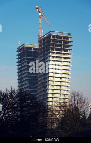 Grue sur le site de construction de gratte-ciel avec windows reflétant sky Banque D'Images