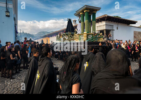 Antigua, Guatemala - Avril 19, 2014 : Gens portant des robes noires et des hottes dans une rue de la vieille ville d'Antigua au cours d'une procession de la Semaine Sainte, Banque D'Images