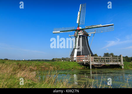 Moulin historique dans l'eau paysage. Moulin De Helper près de Haren à Groningue, aux Pays-Bas. Banque D'Images
