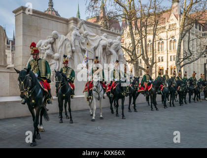 Hussards sur les chevaux en face de la Maison du Parlement pendant la parade du 15 mars à Budapest, Hongrie. Cavalerie hussard en fête traditionnelle uniforme. Banque D'Images