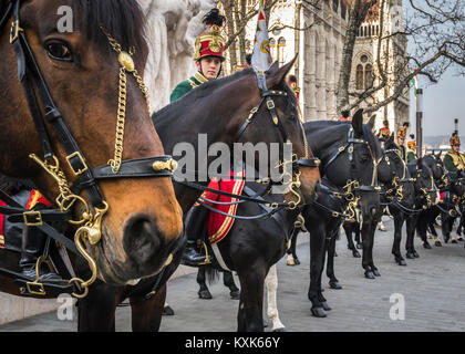 Hussards sur les chevaux en face de la Maison du Parlement pendant la parade du 15 mars à Budapest, Hongrie. Cavalerie hussard en fête traditionnelle uniforme. Banque D'Images