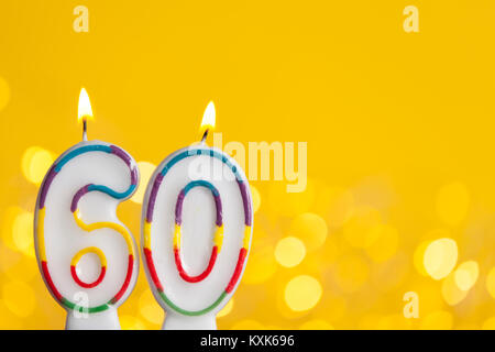 Bougie célébration de l'anniversaire de numéro 60 contre une lumière vive et fond jaune Banque D'Images