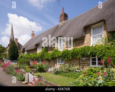 Chaumières avec Saint Pierre et Saint Paul's Church, Kings Sutton, près de Banbury, Northamptonshire, Angleterre, Royaume-Uni, Europe Banque D'Images