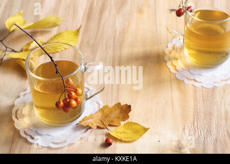 Plateau en verre sur une table en bois avec feuilles et baies Banque D'Images