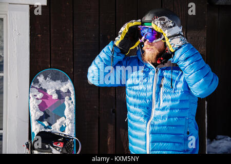 L'Homme à lunettes réglage skiwear,snowboard,à côté de lui Banque D'Images