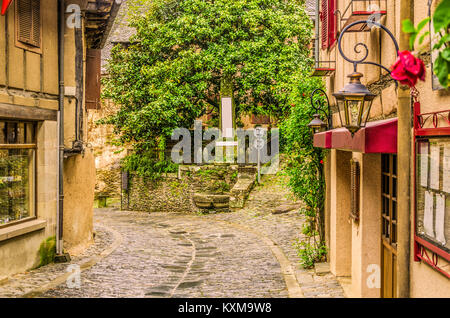 Croisement de rues étroites et monolith à la tombée de la guerre dans l'ancien village médiéval de Conques sur couches de la rivière Dordou France Banque D'Images