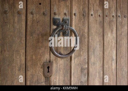 Retro heurtoir en forme d'un anneau est fixé sur une porte en bois. Banque D'Images