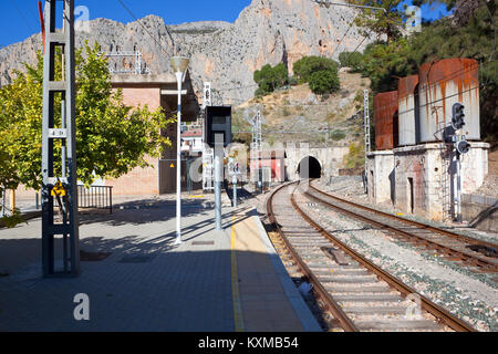 El Chorro gare en andalousie espagne avec une ligne de chemin de fer dans un tunnel en courbe et la roche sous un ciel bleu Banque D'Images