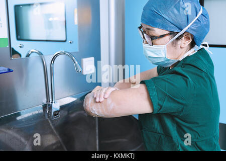 Theatre nurse lave-bras en maternité d'opération Banque D'Images