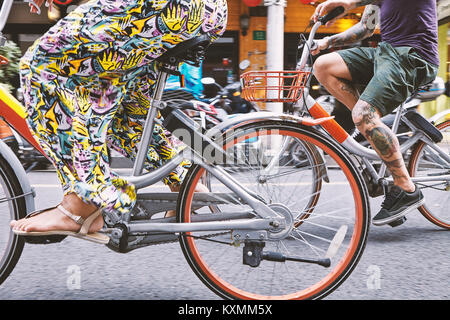 Taille en bas de l'affichage multi ethnic couple hipster le vélo le long de la Concession française de Shanghai,rue,Shanghai,Chine Banque D'Images