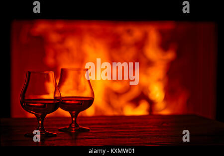 Deux verres de Brandy en face d'une cheminée Banque D'Images