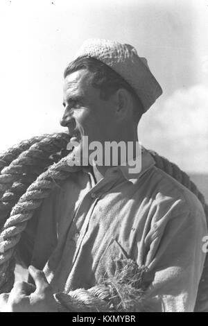 Photographie historique d'un arrimeur travaillant au port de tel Aviv en Israël, documentant le travail maritime et les activités de transport maritime au début du XXe siècle. Banque D'Images