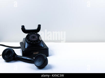 Vintage noir piano avec téléphone à cadran rotatif classique isolé sur fond blanc Banque D'Images