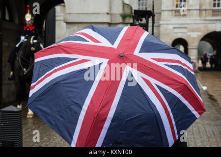 Londres, Royaume-Uni. Jan 11, 2018. Un touriste portant un parapluie Union Jack se place en avant d'un montent la garde en Horseguards Parade. Credit : Mark Kerrison/Alamy Live News Banque D'Images