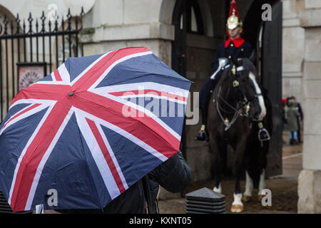 Londres, Royaume-Uni. Jan 11, 2018. Un touriste portant un parapluie Union Jack se place en avant d'un montent la garde en Horseguards Parade. Credit : Mark Kerrison/Alamy Live News Banque D'Images