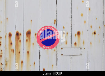 Ancienne porte de garage en bois avec no parking sign en Français Banque D'Images