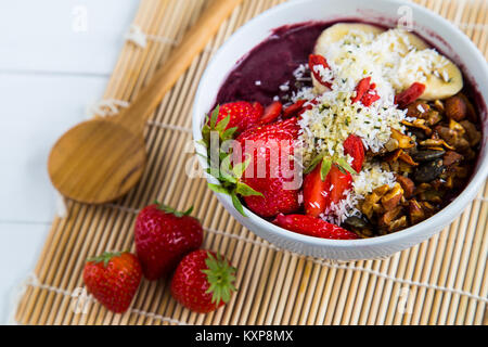 Bol d'Acai et fraises - Bol de purée d'açaï des garnitures de banane, fraise, granola et les graines. Banque D'Images