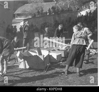 Une photographie de 1940 capturant une scène de désordre impliquant des caisses brisées et des patins éparpillés, reflétant les perturbations industrielles ou de stockage de la période. Banque D'Images