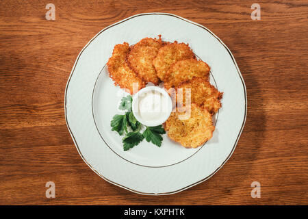 Vue de dessus les escalopes de sauce de pommes de terre frites dans une soucoupe sur plaque sur la surface en bois Banque D'Images