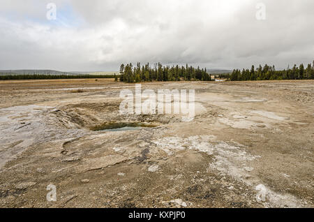 Ciel bleu avec des nuages sur Opal Pool dans le Midway Geyser Basin avec la rivière Firehole en arrière-plan sur la droite Banque D'Images