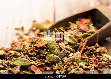 Scoop en bois avec un mélange d'infusion de thé épicé sur table Banque D'Images