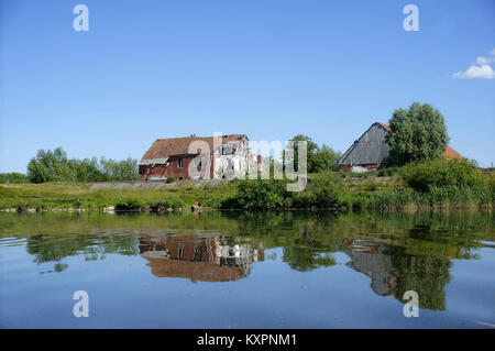 Les maisons qui se reflètent dans la surface du lac Le lac, calme, une ancienne maison solitaire sur le lac Banque D'Images