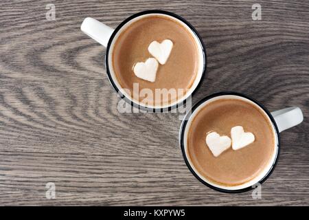 Deux tasses de chocolat chaud avec des guimauves en forme de cœur sur un fond de bois Banque D'Images