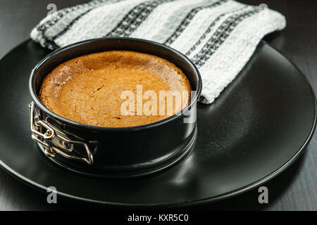 Gâteau au fromage au chocolat maison dans petit moule sur la plaque noire sur la table. Banque D'Images