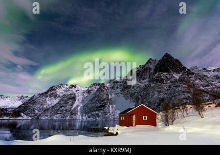 Les Lofoten, Svolvær, Aurora Borealis, sur un lac gelé et rouge, en Norvège. rorbu Banque D'Images