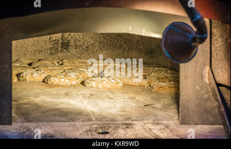 Du pain frais à la boulangerie rustique avec four en pierre traditionnelle Banque D'Images