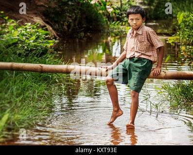 Petit garçon dans un étang de détente après l'école à Yangon, Myanmar Banque D'Images