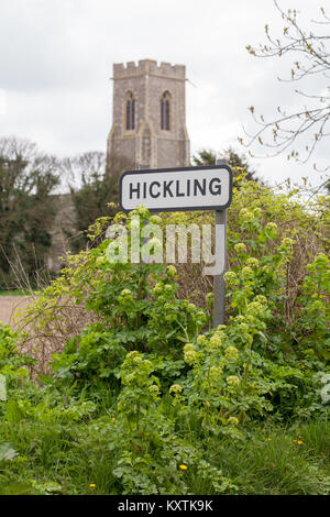 Route de village signe avec l'église Sainte Marie de l'arrière-plan. VILLAGE HICKLING, Norfolk, Broadland. L'East Anglia. ENGLAND UK. Remarque Alexanders vert frais Banque D'Images